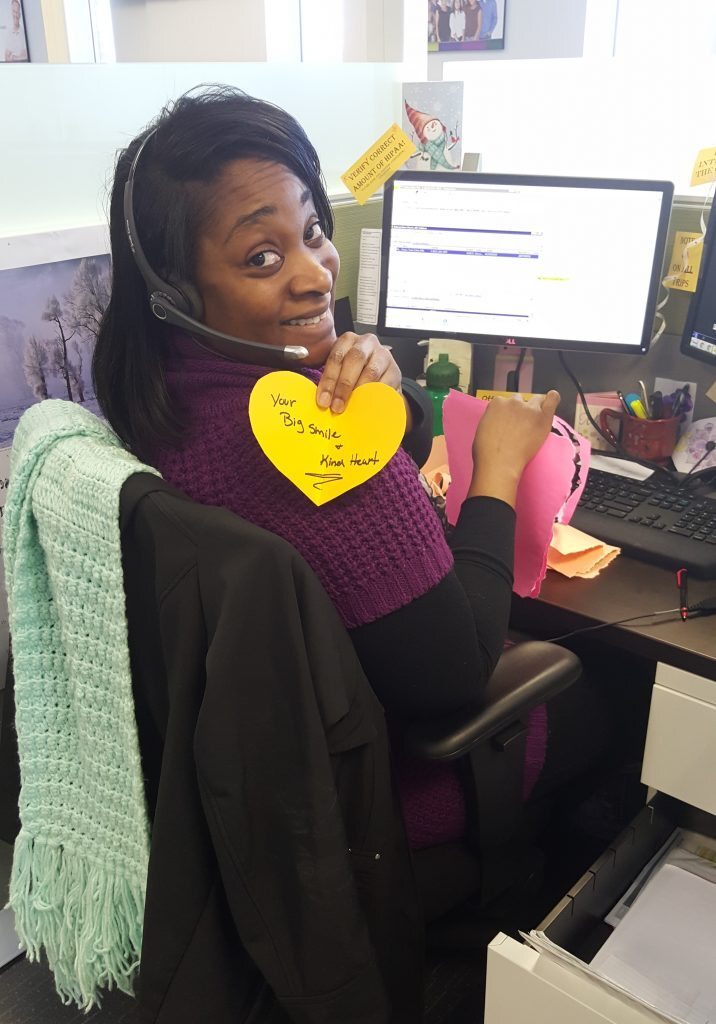 Employee holding paper heart with compliment on it