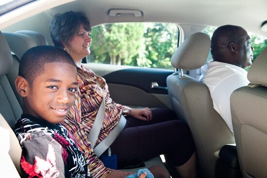 Child, guardian and driver in a car